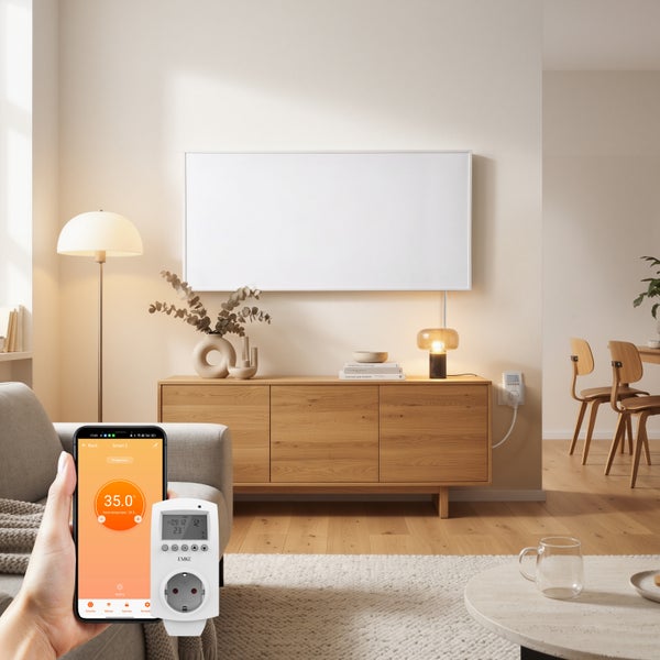 Ruka drží smartphone s ovládáním přes aplikaci vedle zásuvkové bezdrátové termostatické hlavice v moderním obývacím pokoji.