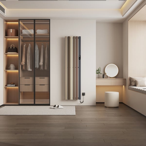 Moderní designový radiátor vertikálně namontovaný ve světlé ložnici se šatní skříní a toaletním stolkem.