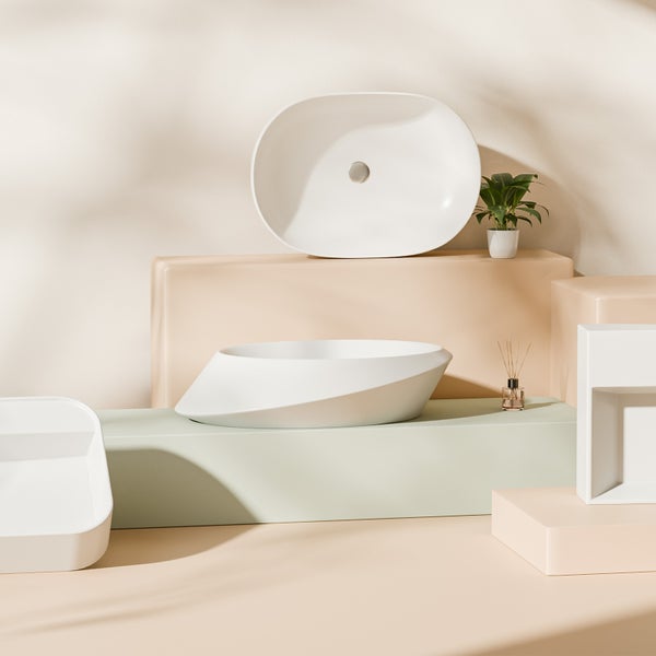 Na obrázku jsou dvě umyvadla na desku a jedno zapuštěné umyvadlo ve světlé koupelně. Design je moderní a minimalistický.