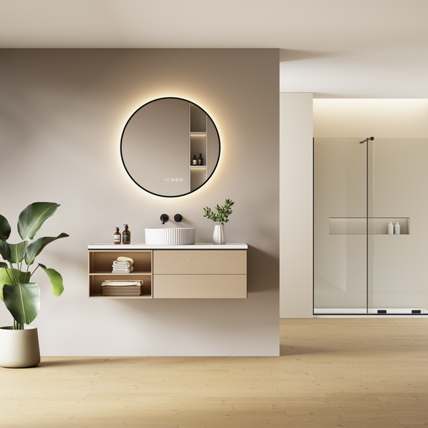 Moderní koupelna s umyvadlovou skříňkou, kulatým LED zrcadlem a sprchovým koutem v minimalistickém a organickém designu.