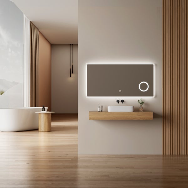 Moderní koupelna s osvětleným zrcadlem, závěsnou dřevěnou koupelnovou skříňkou a volně stojící vanou v minimalistickém designu.
