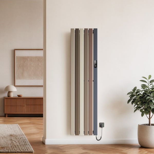 Svislý designový radiátor s digitálním termostatem namontovaný na světlé stěně v moderně zařízeném obývacím pokoji