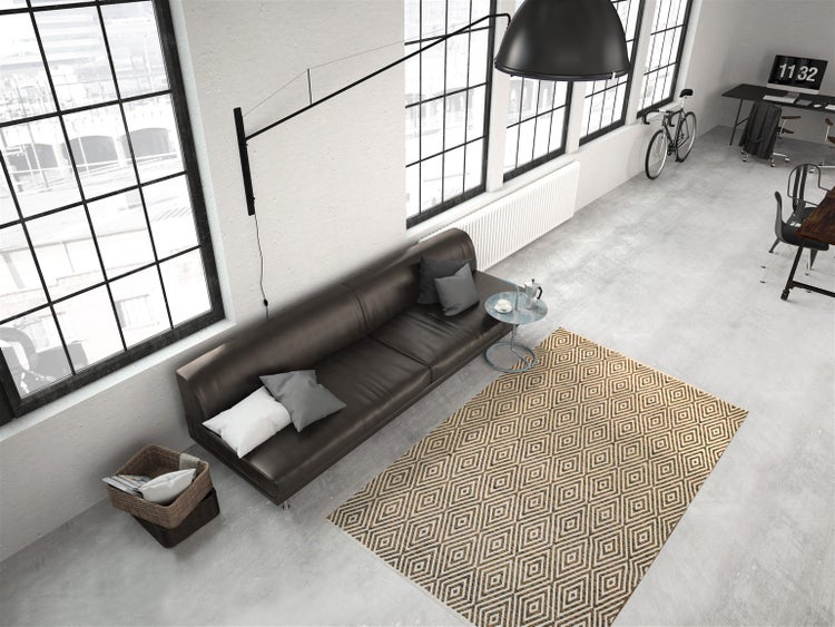 Moderní koberec s geometrickým kosočtvercovým vzorem ve světlém obývacím pokoji v industriálním stylu loft s koženou pohovkou.