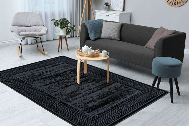 Detailní záběr na tkaný koberec s abstraktním geometrickým vzorem.