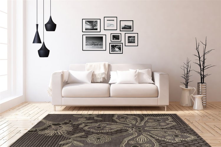 Moderní světlý obývací pokoj s bílou pohovkou, vzorovaným kobercem, černými závěsnými svítidly a galerií fotek na světlé parketové podlaze.