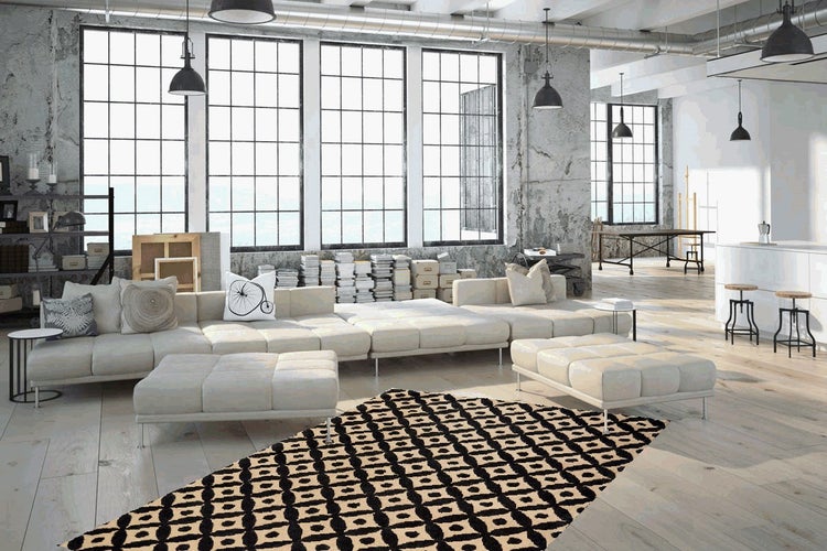 Prostorný, světlý obývací pokoj v industriálním stylu s modulární pohovkou, taburety a geometrickým kobercem na dřevěné podlaze.