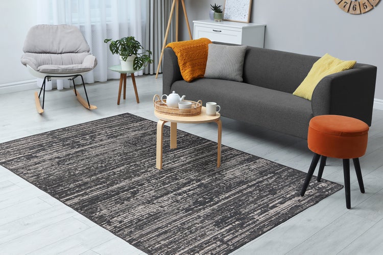 Detailní záběr na tkaný koberec se strukturovaným povrchem a lineárním vzorem.
