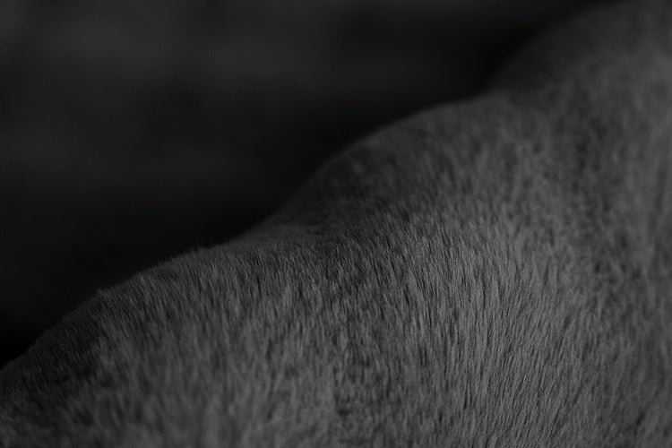 Detailní záběr na měkký povrch umělé kožešiny v antracitové barvě.