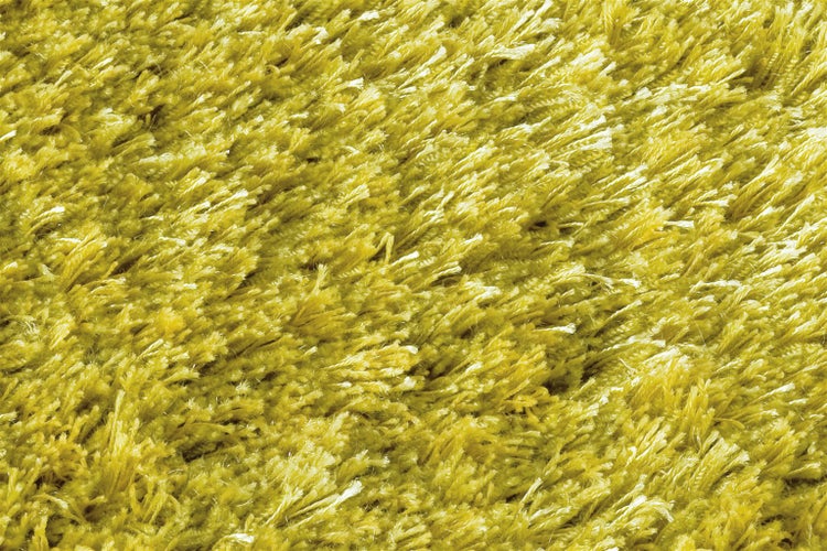 Detailní záběr na žlutý koberec s vysokým vlasem a huňatou texturou.