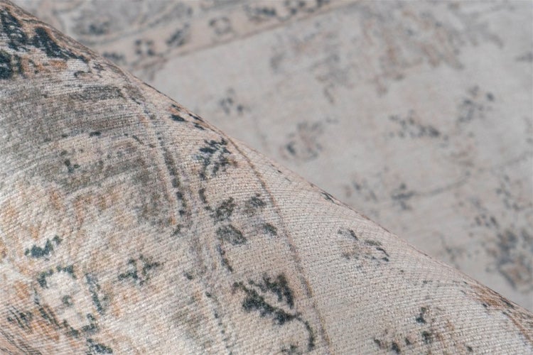 Detailní pohled na tkaný koberec s orientálním vintage vzorem a měkkou texturou.
