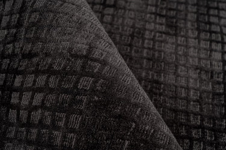 Detailní pohled na antracitový koberec s kostkovaným vzorem a strukturovaným povrchem.