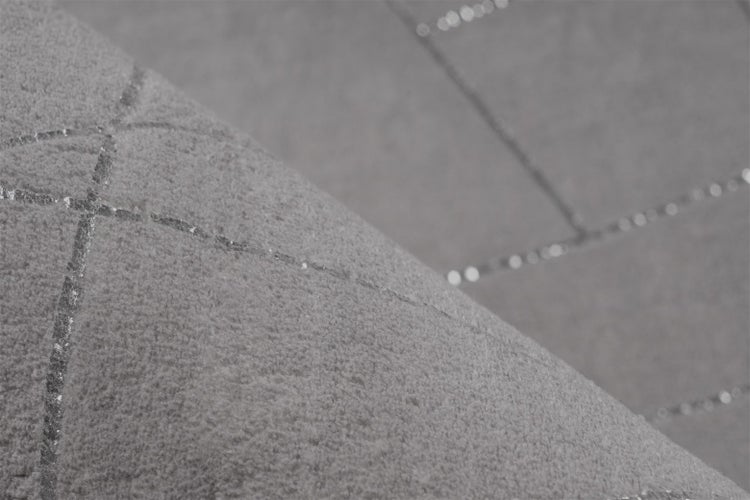 Detailní záběr na šedou strukturovanou tapetu s lesklým geometrickým vzorem linií.