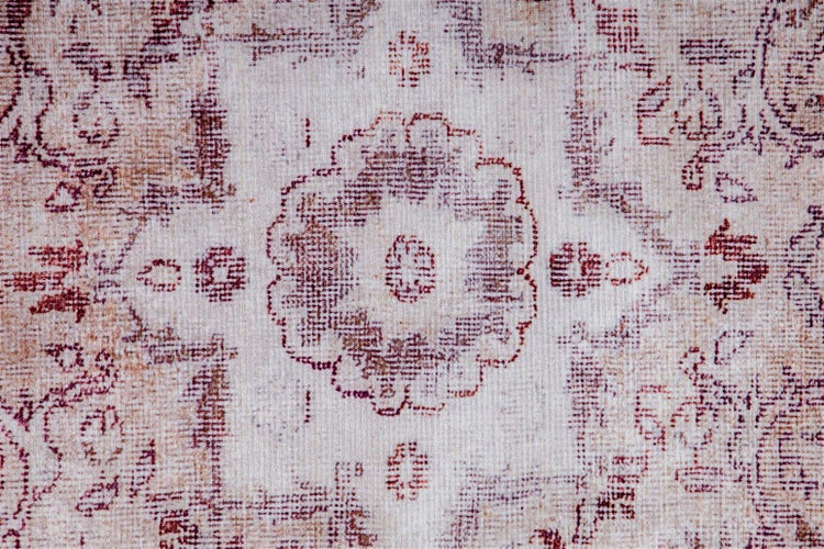Detail koberce s orientálním vintage vzorem a středovým medailonem.
