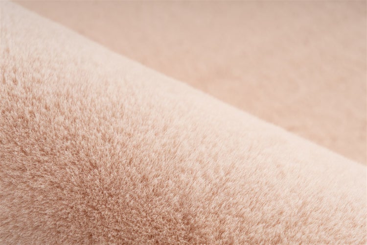 Detailní záběr na texturu béžového koberce s vysokým vlasem.