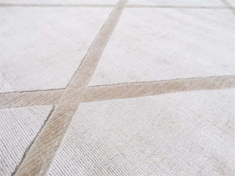Detail koberce s geometrickým kosočtvercovým vzorem a měkkou strukturou vlasu.