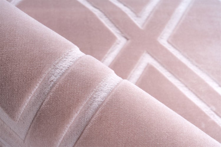 Detailní pohled na koberec s geometrickým vzorem a měkkým povrchem.