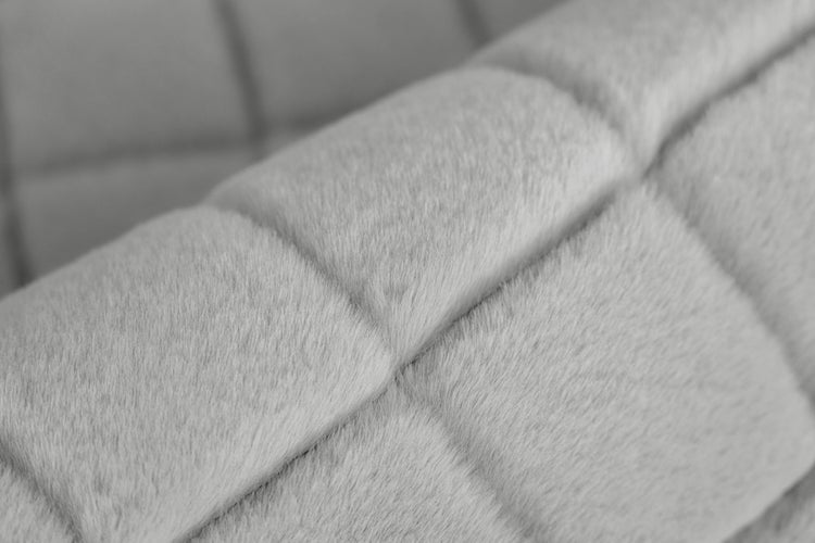Detail měkkého koberce z umělé kožešiny se čtvercovým prošíváním a protiskluzovou zadní stranou.