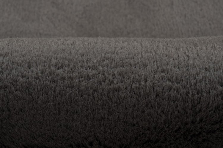 Detailní pohled na měkký tmavě šedý koberec z umělé kožešiny s hustým vlasem.