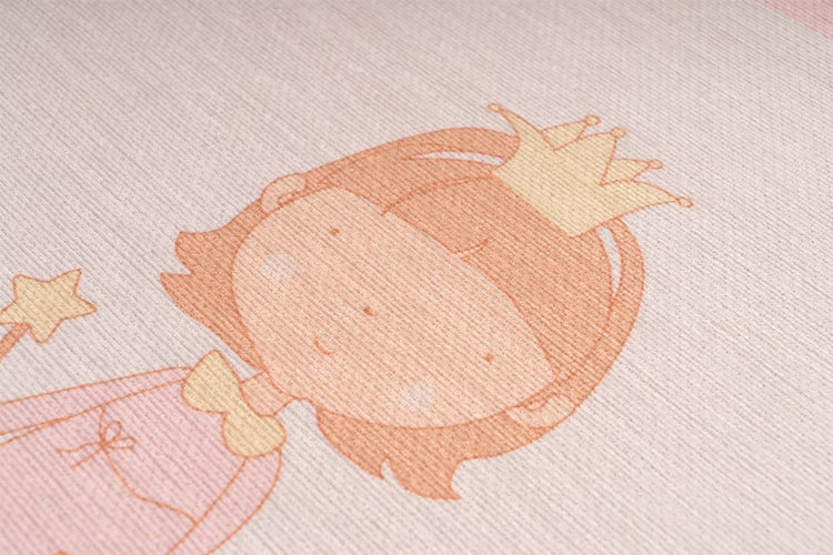 Detailní záběr dětského koberce s motivem princezny, korunkou a hvězdnou hůlkou na strukturovaném povrchu.