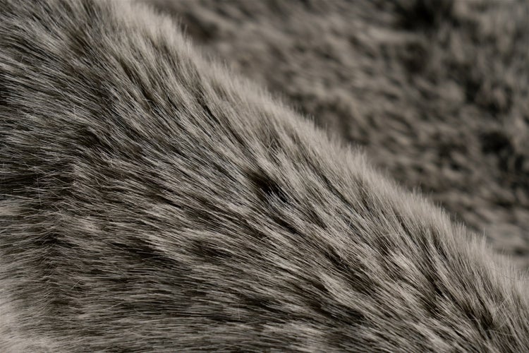 Detailní záběr na měkkou texturu umělé kožešiny s dlouhými vlákny.