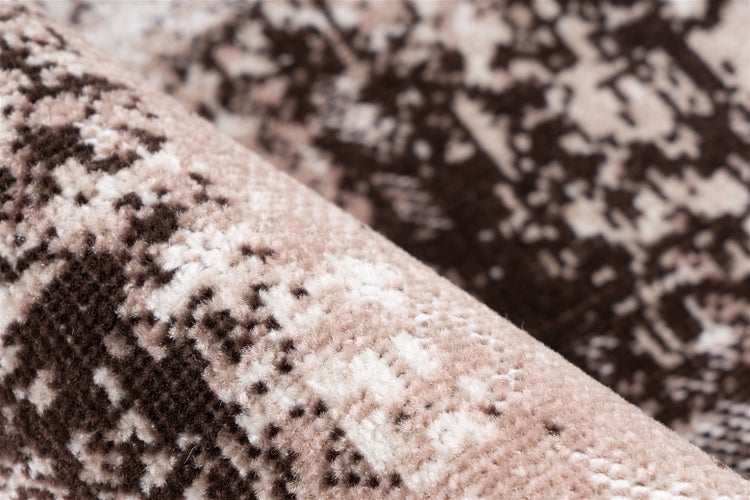 Detailní záběr na měkký vzorovaný koberec s vysokým vlasem a abstraktním designem.