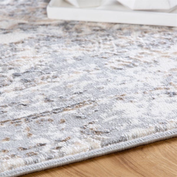 Detail koberce ve vintage stylu s šedým a béžovým vzorem na dřevěné podlaze.