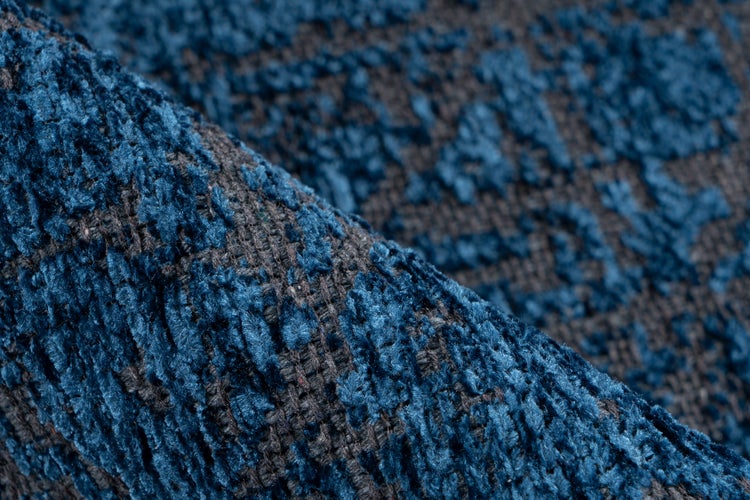 Detailní záběr na texturovanou tkaninu s měkkým povrchem v modré a šedé barvě.