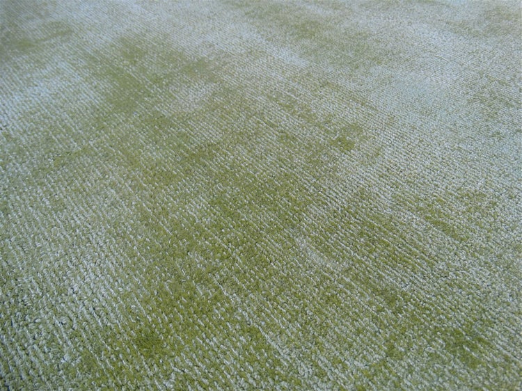 Detailní záběr na zelený koberec s žebrovanou strukturou a smyčkovým vlasem.