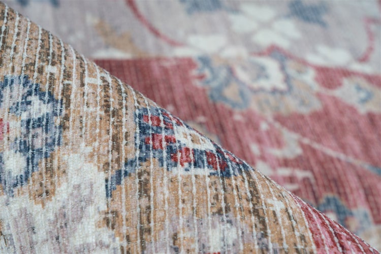 Detailní pohled na koberec s orientálním vzorem ve vintage stylu s ohrnutým okrajem.