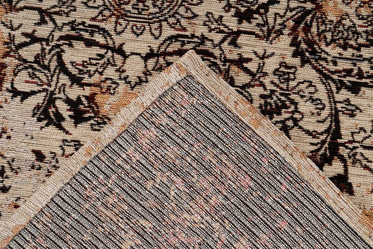 Detailní pohled na koberec s orientálním vzorem ve vintage stylu s viditelnou tkanou zadní stranou.