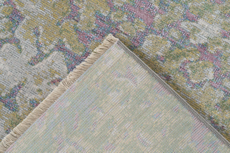 Detailní záběr tkaného koberce s vintage vzorem, okrajem s třásněmi a rubovou stranou.