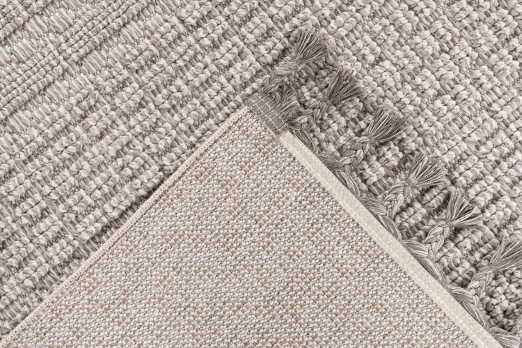 Strukturovaný koberec s třásněmi, detailní záběr na povrch a zadní stranu, tkaný textilní materiál.
