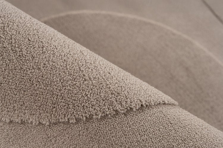 Detailní pohled na strukturu koberce s krátkým vlasem a smyčkovým povrchem ze syntetického materiálu.