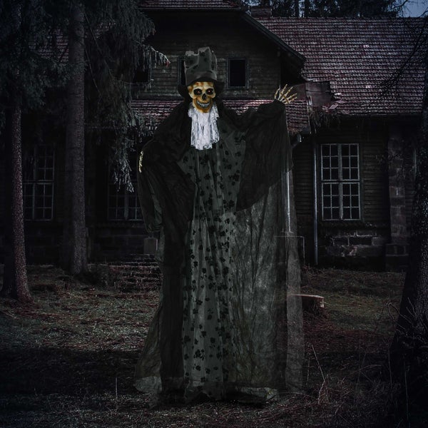 Halloweenská dekorace strašidelné postavy ducha před temným, strašidelným domem.