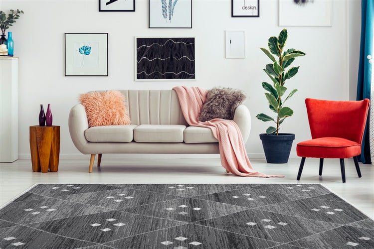 Detailní záběr na koberec s abstraktními geometrickými vzory a strukturou s krátkým vlasem.