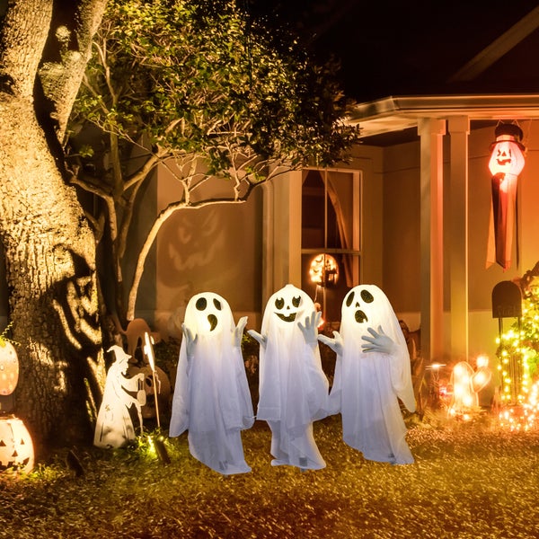 Tři halloweenské dekorace duchů stojí před domem