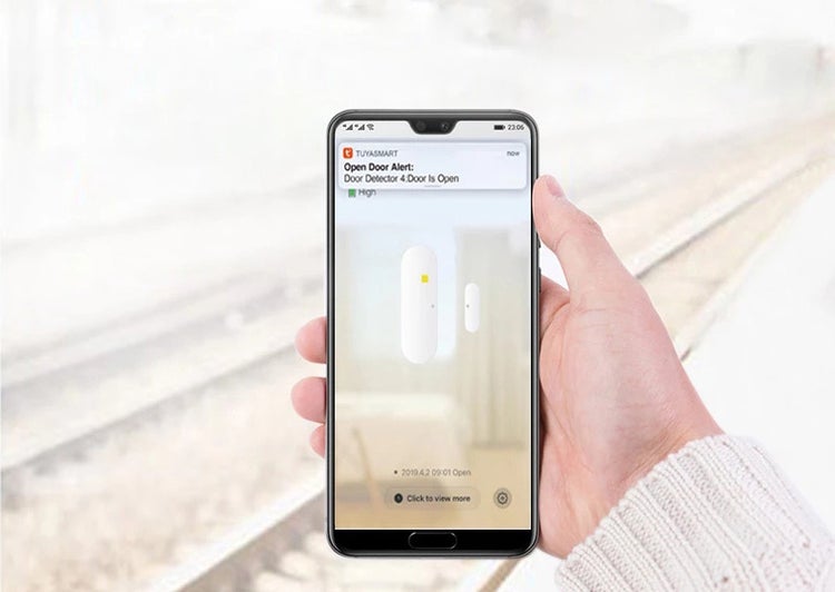 Ruka drží smartphone s upozorněním aplikace Tuya Smart na otevřený dveřní senzor
