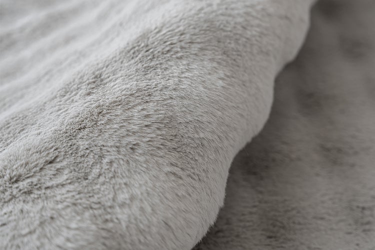 Detailní záběr na měkký materiál z umělé kožešiny pro koberce nebo deky.