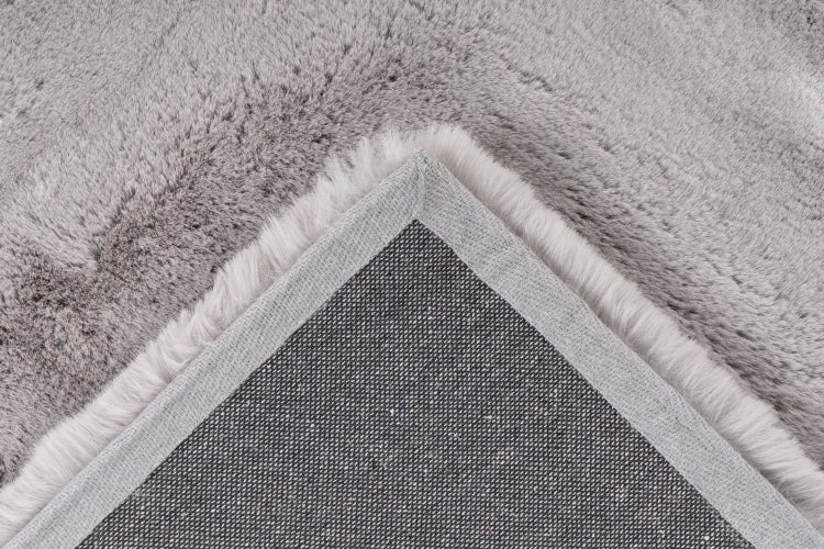 Detailní pohled na spodní stranu a strukturu povrchu chlupatého koberce s vysokým vlasem.