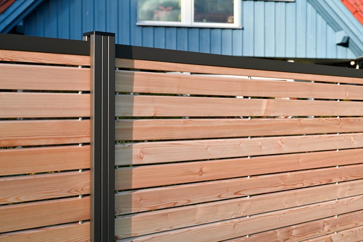 Dřevěný plot s kovovými prvky před domem