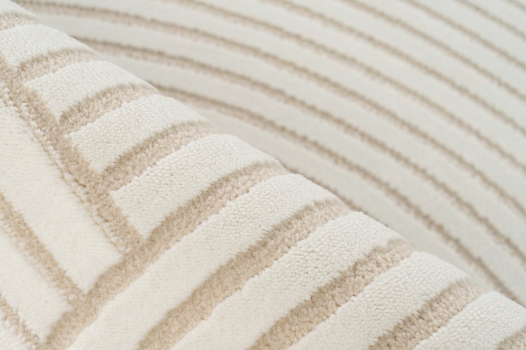Detailní záběr na koberec s pruhovaným tkaným vzorem z měkkého materiálu