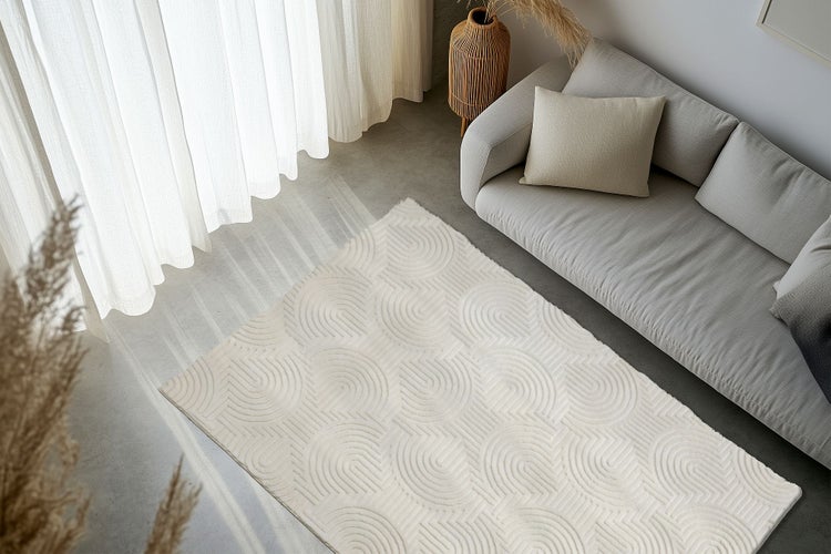 Obývací pokoj s moderním kobercem s geometrickým vzorem oblouků před pohovkou na betonové podlaze.