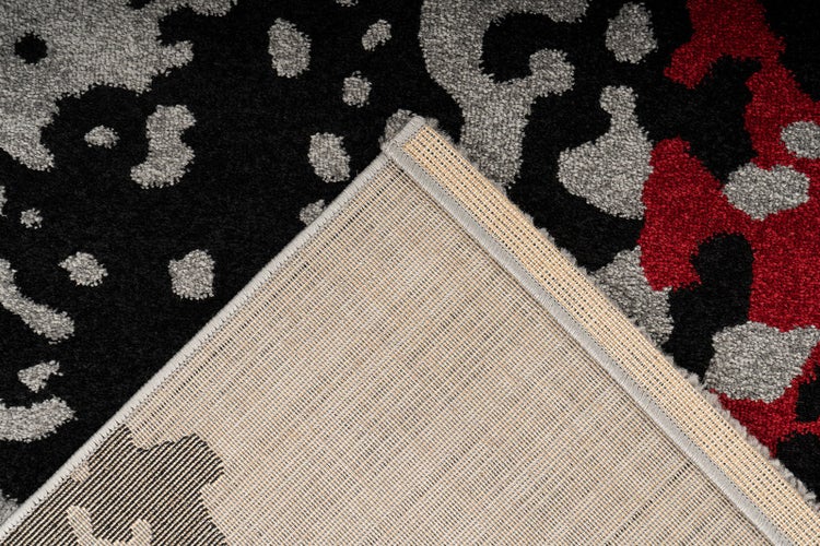 Koberec s leopardím vzorem v černé, šedé a červené barvě, detailní pohled na povrch a tkanou rubovou stranu.