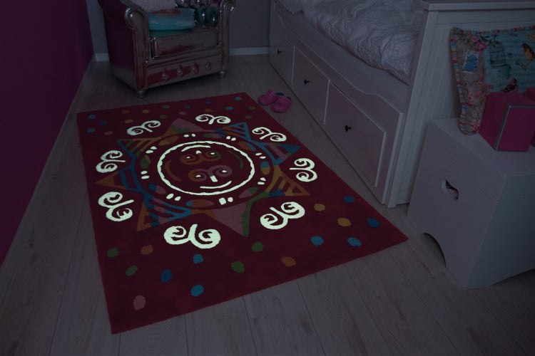 Obdélníkový dětský koberec se svítícím designem slunce v dětském pokoji na světlé podlaze.