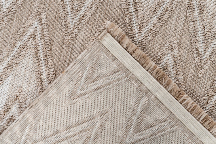 Detailní záběr na koberec s geometrickým vzorem, který ukazuje strukturovaný povrch a tkanou zadní stranu s lemováním.