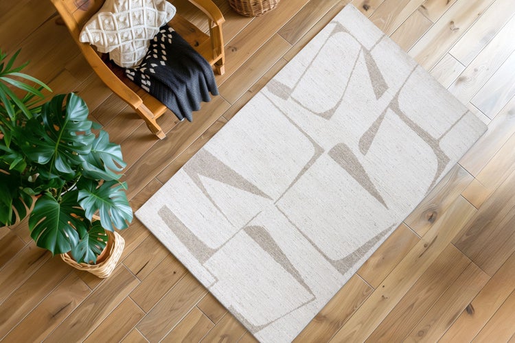 Obdélníkový koberec s abstraktním geometrickým vzorem na dřevěné podlaze v moderně zařízeném obývacím pokoji.