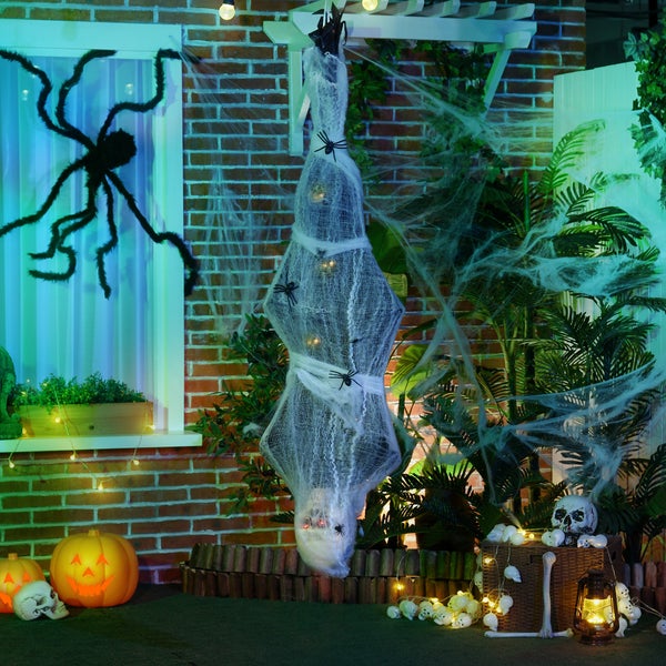 Halloweenská dekorace s dýněmi, pavučinou a lebkami před domem