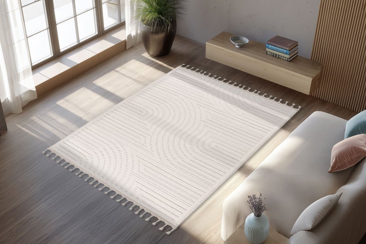 Obývací pokoj se světlým kobercem s geometrickým vzorem linek a střapci na dřevěné podlaze v moderně zařízené místnosti s pohovkou.