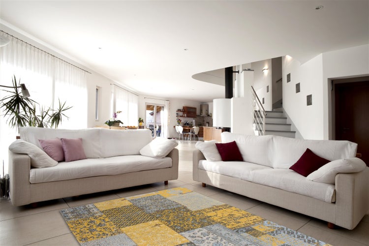 Otevřený, světlý obývací pokoj se dvěma pohovkami, krbem, dlažbou a vzorovaným kobercem v moderním interiérovém designu.