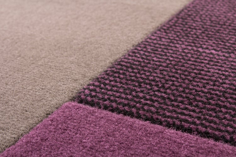 Detailní záběr na koberec s různými strukturami povrchu v geometrickém vzoru
